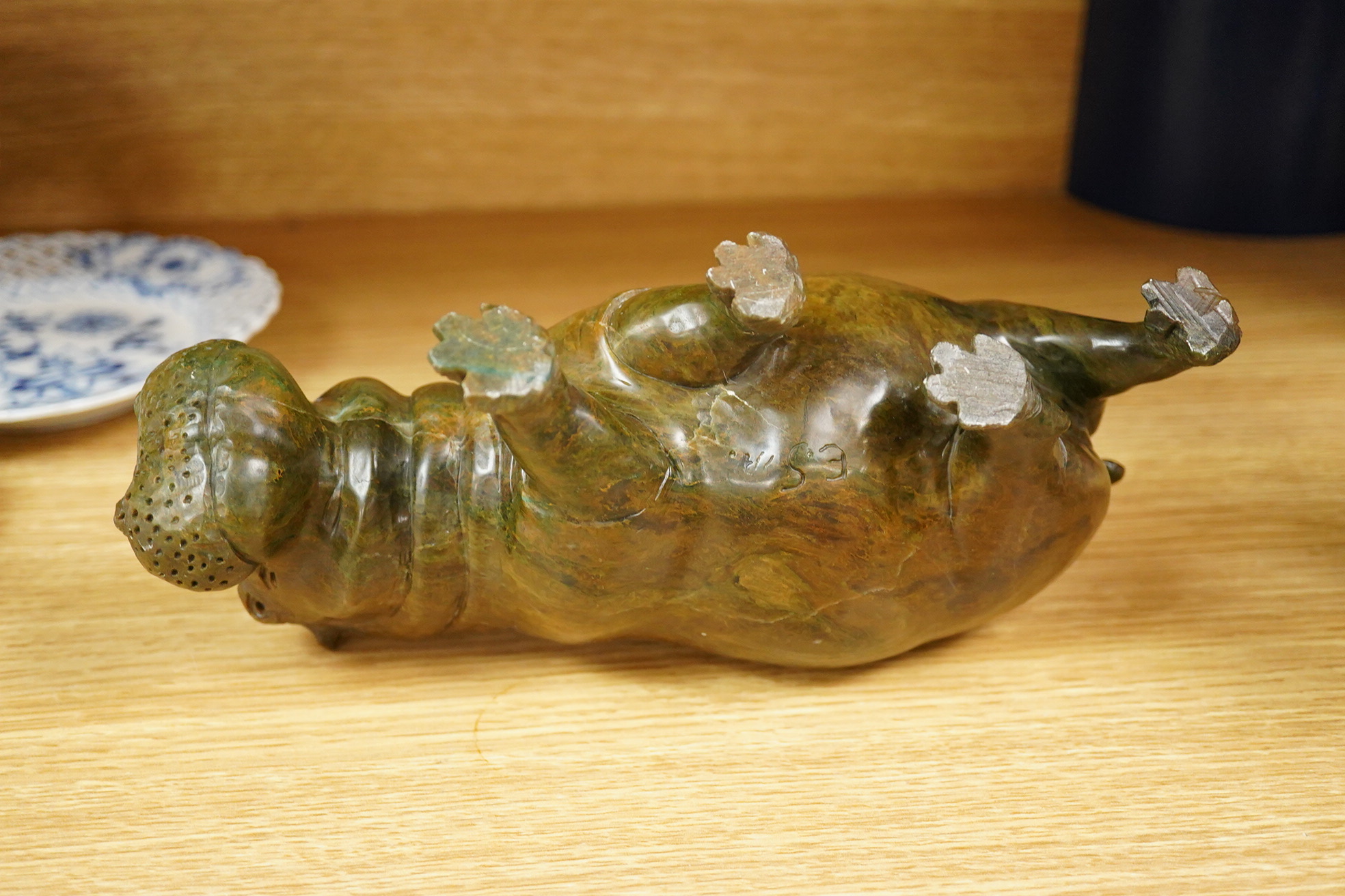 A carved serpentine study of a walking hippopotamus, incised initials to the underside 'E.S.', 24cm wide